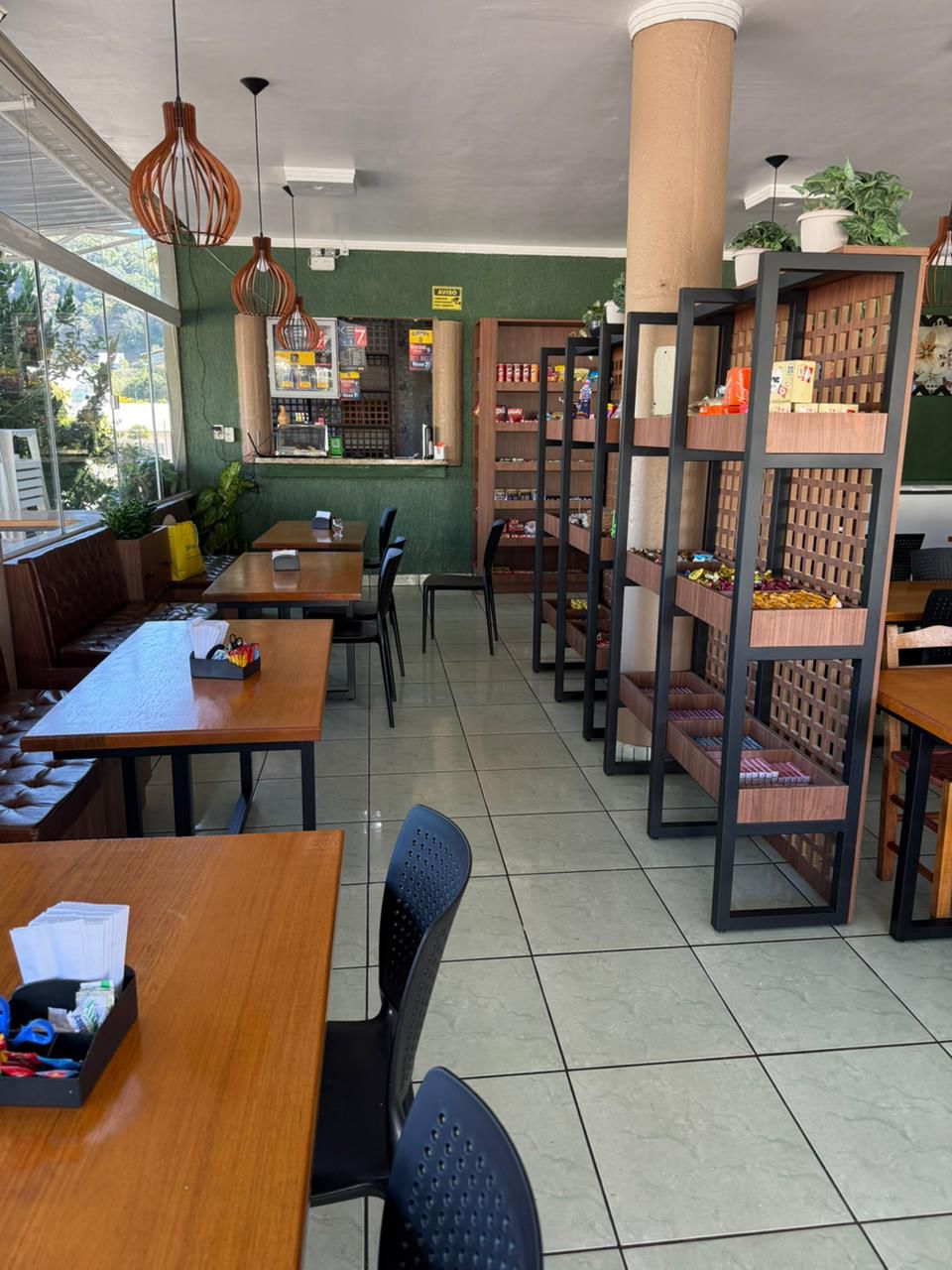 Cafeteria com estantes metálicas pretas e madeira amendoim — projeto comercial SCHREINER